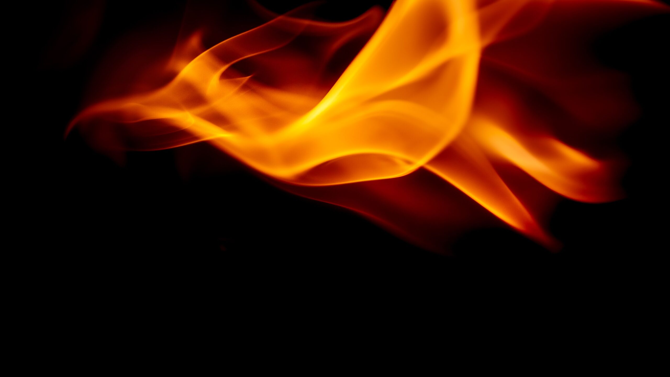 Vibrant orange flames dancing against a dark background, showcasing dynamic movement and intensity.